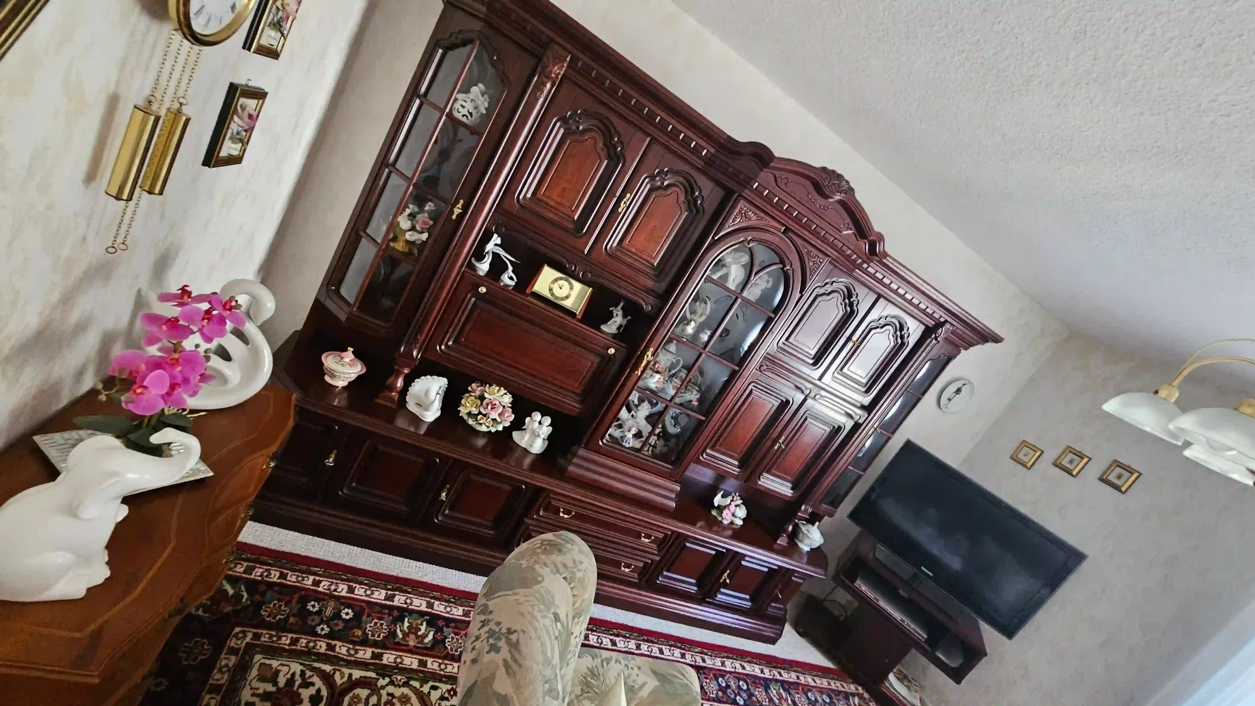 Haushaltsauflösung Wohnzimmer mit großer Holzschrankwand, Dekoration und Fernseher